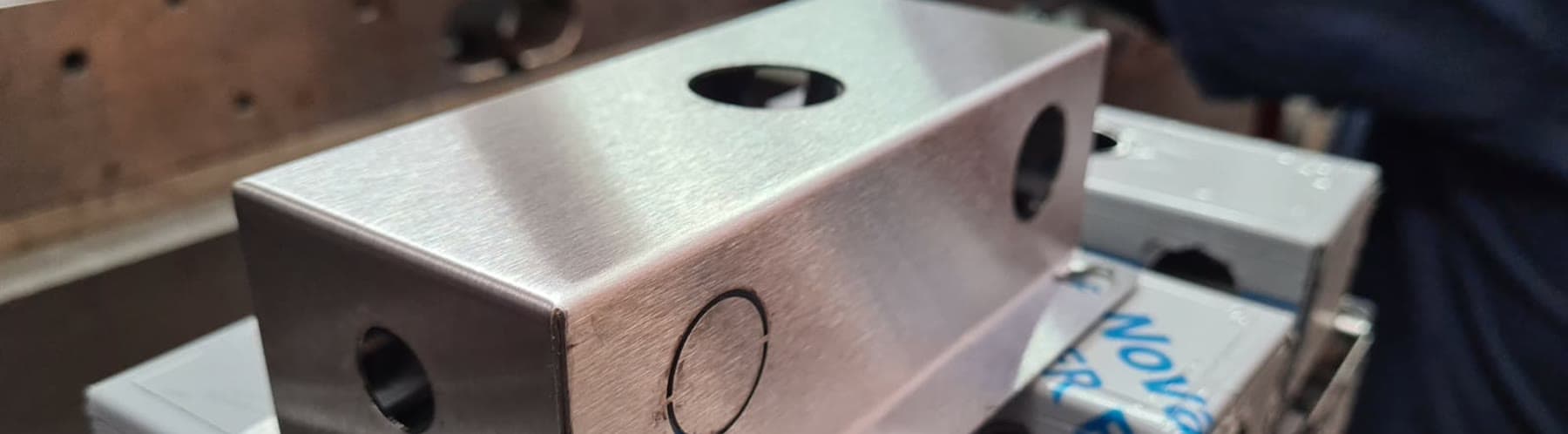 Caja de acero inoxidable plegada en Oxpane, con agujeros ubicados lejos de los dobleces.