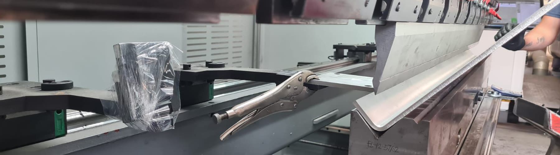 Punzón y matriz de una plegadora CNC Bystronic en la planta de Oxpane, con una chapa recién plegada.